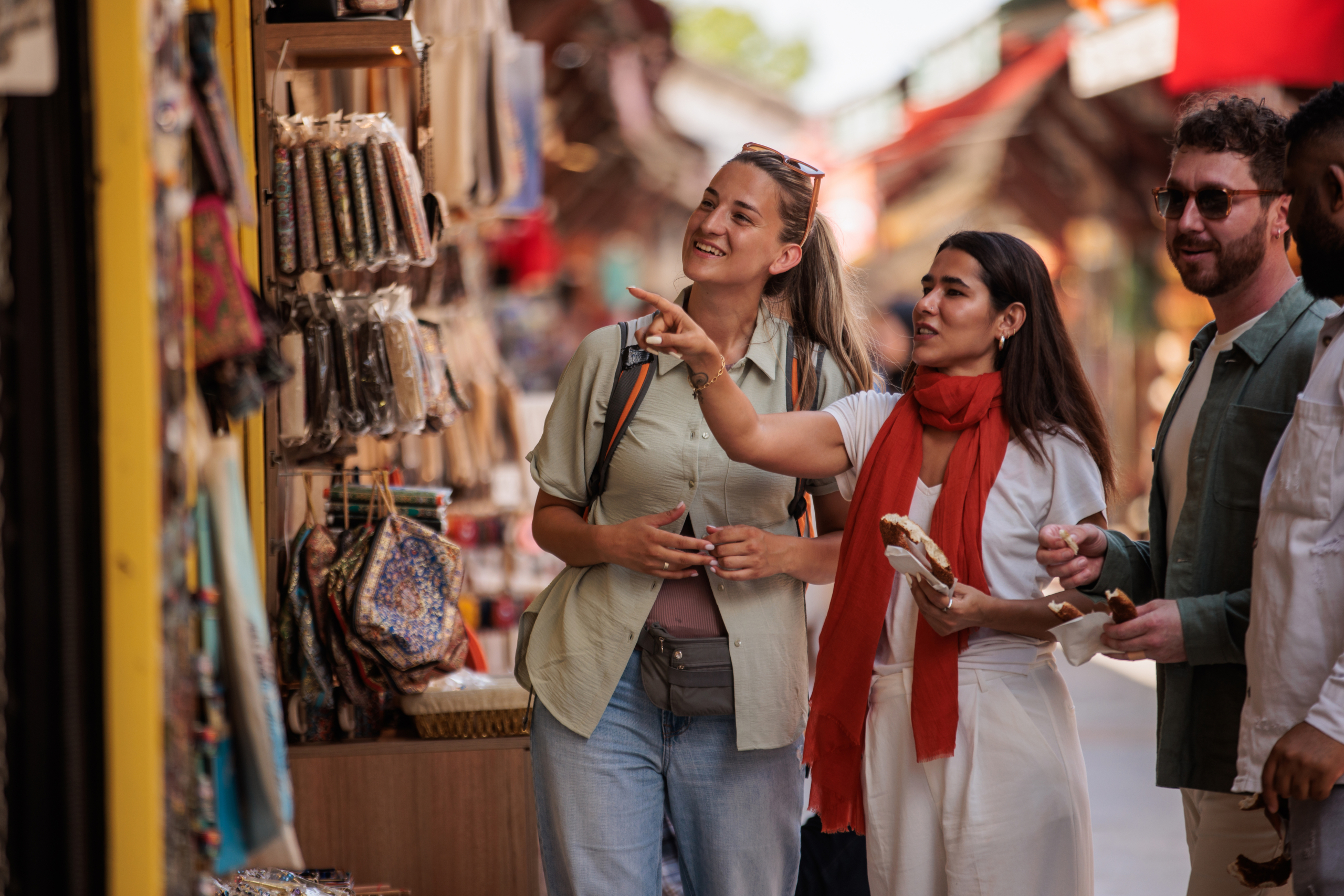 Dos mujeres caminando por un mercadillo de artesanías.